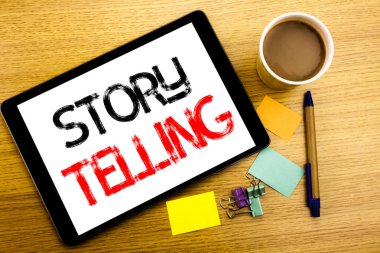 El yazısı metnini başlık hikaye anlatımı gösterilen. Yazmak için Teller hikaye mesaj yazılmış tablet laptop, yapışkan not, kahve ve kalem ile ahşap arka plan iş kavramı