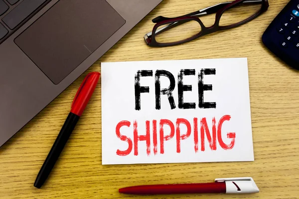 Kavramsal el ücretsiz nakliye gösterilen metin yazma. Teslimat için kağıt, ahşap arka plan kopya alanı, pen marker ve gözlük ofiste yazılı taşıma için iş kavramı