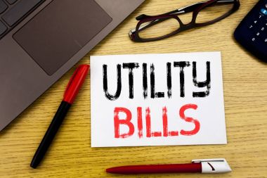 Kavramsal el Utility faturaları gösterilen metin yazma. İş kavramı para Bill içinde yazıhane kopya alanı, pen marker ve gözlük ile kağıt, ahşap arka plan üzerinde yazılı ödeme için