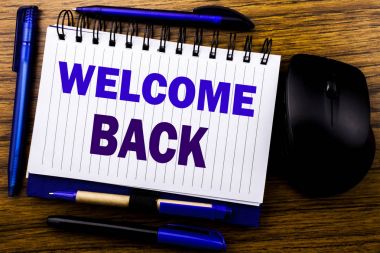 Hoş geldiniz geri gösteren el yazısı metin. Duygu defter kitap bir not kağıdına ahşap arka plan üzerinde yazılı tebrik için iş kavramı. Mavi word mektup. Fare için ileri.