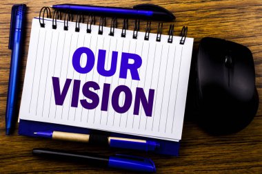 Bizim vizyon gösteren el yazısı metin. İş kavramı için pazarlama stratejisi vizyon defter kitap bir not kağıdına ahşap arka plan üzerinde yazılı. Mavi word mektup. Fare için ileri.