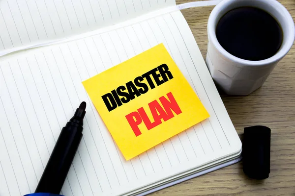 Hand writing text caption inspiration showing Disaster Plan. Business concept for Emergency Recovery written on sticky note paper, Wooden background with space, Coffee and marker