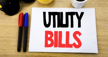 El yazısı metnini başlık Utility faturaları gösterilen. Para Bill ile güneş gözlüğü ile eski ahşap ahşap arka plan üzerinde kopya alanı üzerinde yapışkan not yazılı ödeme için yazma iş kavramı