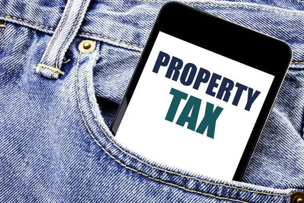 Conceptual hand writing text caption inspiration showing Property Tax. Business concept for Estate Income Taxation Written phone mobile phone, cellphone placed in the man front jeans pocket.