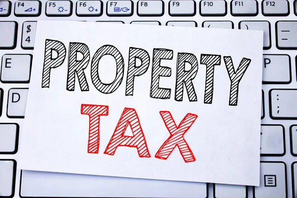 Handwritten text caption showing Property Tax. Business concept writing for Estate Income Taxation written on sticky note paper on the white keyboard background. — Stock Photo, Image