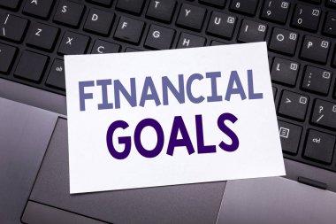 El yazma metin ilham gösteren mali hedefleri alt yazı. Yapışkan not kağıdına siyah klavye arka plan üzerinde yazılı para gelir planı için iş kavramı.