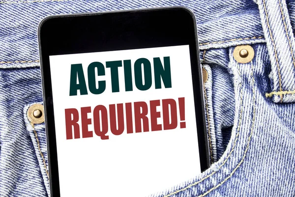 Hand writing text caption inspiration showing Action Required. Business concept for Immediate Urgent written on smartphone in the jeans pants. Blue background. — Stock Photo, Image