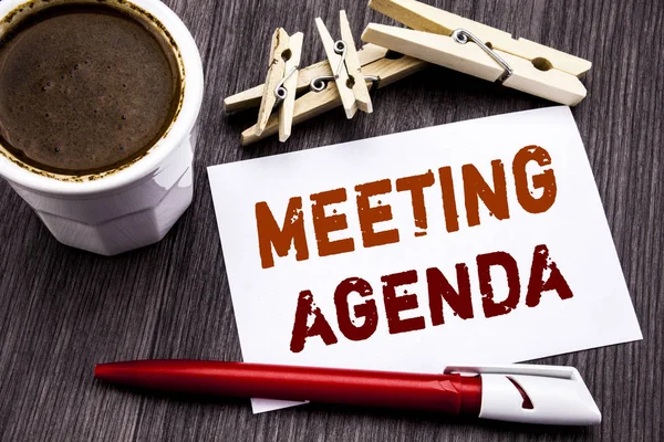 Hand writing text caption inspiration showing Meeting Agenda. Business concept for Business Schedule Plan written on sticky note paper on the wooden wood background. With coffee and red pen. — Stock Photo, Image