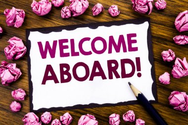 Hand writing text caption inspiration showing Welcome Aboard. Business concept for Greeting Join Member Written on sticky note paper, wooden background with folded pink paper meaning thinking clipart