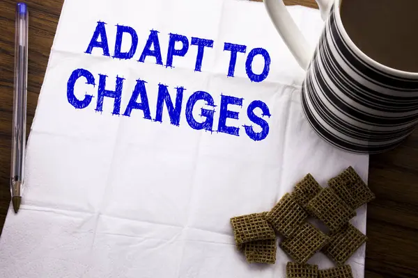 Hand writing text caption showing Adapt To Changes. Business concept for Adaptation New Future written on tissue paper on the wooden background with pen and healthy coffee in the restaurant — Stock Photo, Image