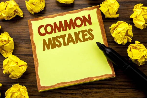 Hand writing text caption showing Common Mistakes. Business concept for Common Concept Written on sticky note paper, wooden background with marker folded yellow paper meaning thinking — Stock Photo, Image