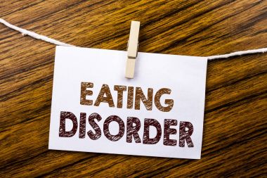 Yeme bozukluğu gösteren el yazısı duyuru metin. İş kavramı için tıbbi Problem ahşap arka plan üzerinde yapışkan not kağıt üzerinde yazılı.