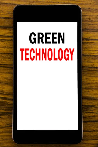 Почерк Объявление текста, показывающего зеленые технологии. Бизнес-концепция кампании, написанная на мобильном телефоне с деревянным фоном на столе — стоковое фото