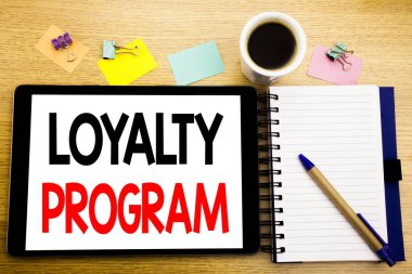 Word, sadakat programı yazma. Pazarlama kavramı yazılı tablet laptop, yapışkan not, kahve ve kalem ile ahşap arka plan için iş kavramı