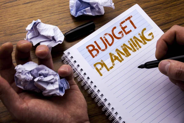 Word, writing Budget Planning. Concept for Financial Budgeting written on notebook notepad note paper on the wooden background with folded paper meaning thinking for idea. Man hand and marker.