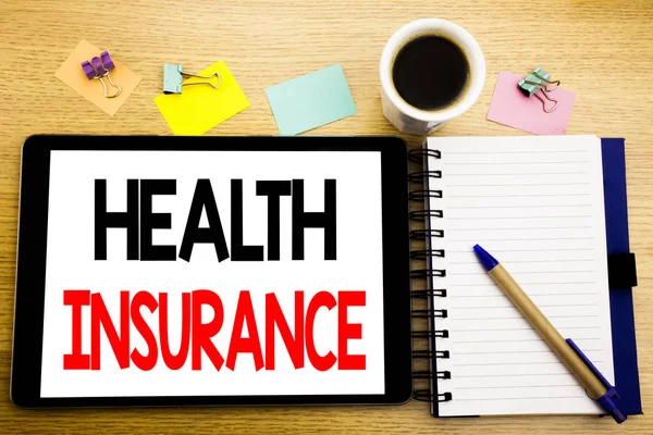 Word は、健康保険を書きます。医療ヘルスケアは、タブレットのラップトップ上のクチ、付箋、コーヒー ペンと木製の背景のため事業コンセプト — ストック写真