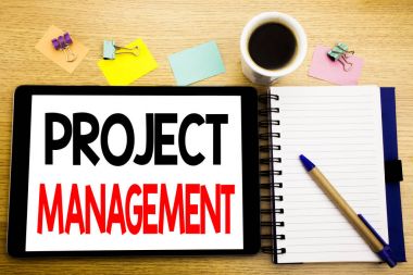 Word, proje yönetimi yazma. Strateji planı gol yazılı tablet laptop, yapışkan not, kahve ve kalem ile ahşap arka plan için iş kavramı