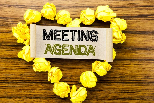 Palavra, escrevendo Agenda da Reunião. Conceito de negócio para Business Schedule Plan escrito em papel de nota pegajosa sobre o fundo de madeira escura. Com coração de papel dobrado amarelo que significa amor ou adoração . — Fotografia de Stock