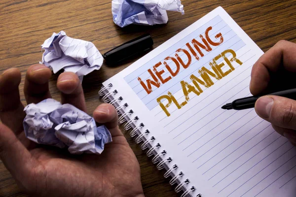 字, 写婚礼策划人。关于婚姻准备的概念写在笔记本记事本笔记纸上的木质背景与折叠纸意义思维的想法。人手和标记. — 图库照片