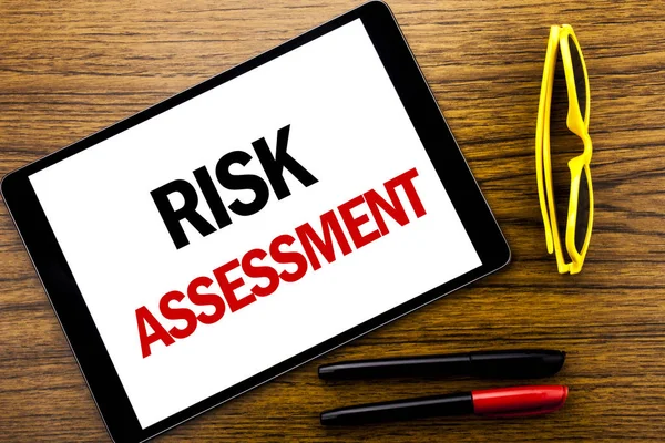 Szöveg írása kockázatértékelés mutatja. Üzleti koncepció biztonsági veszély elemzéséhez írt tabletta laptop, fából készült háttér sárga nyaralás szemüveg és jelölő toll. — Stock Fotó