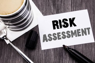 Risk değerlendirmesi gösteren el yazısı duyuru metin. İş kavramı Emanet tehlikeyi ahşap ahşap arka plan üzerinde yapışkan not kağıt üzerinde yazılı analiz için. Cilt kalemi ve kahve ile. Office Üstten Görünüm.
