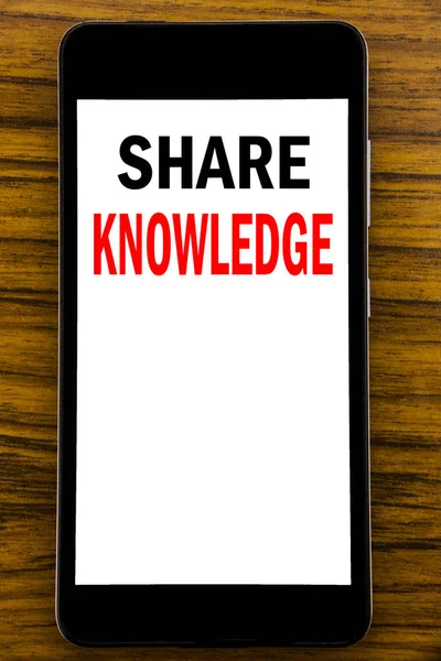 Χειρόγραφο κείμενο ανακοίνωσης δείχνει μοιραστείτε τη γνώση. Επιχειρηματική ιδέα για εκπαίδευση ανταλλαγή γραμμένο στο κινητό τηλέφωνο κινητό με ξύλινο υπόβαθρο με χώρο στο τραπέζι — Φωτογραφία Αρχείου