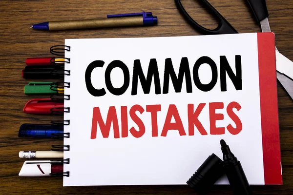 Handwritten text showing Common Mistakes. Business concept for Common Concept Written on notebook, wooden background with office equipment like pens scissors colourful marker — Stock Photo, Image
