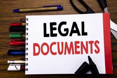 Yasal belgeleri gösteren el yazısı metin. Sözleşme belge yazılı üstünde defter, kalem gibi Ofis donanımı ile ahşap arka plan için iş konsepti renkli marker makas  