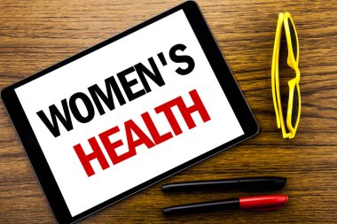 Kadın sağlığı gösterilen metin yazma. Kadın kutlama yazılı tablet laptop, tatil sarı gözlük ve marker kalem ile ahşap arka plan için iş kavramı.