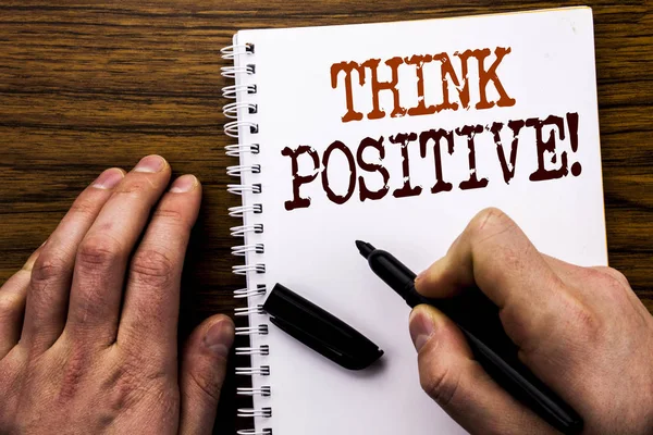 Testo scritto a mano che mostra la parola Think Positive. Business concept per atteggiamento positivo Scritto su tablet laptop, sfondo in legno con mano di uomo d'affari, scrittura di dita su taccuino . — Foto Stock
