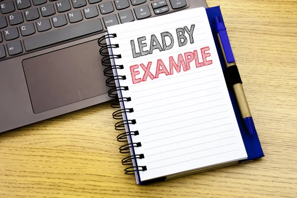 Escrever texto mostrando Lead By Example. Conceito de negócio para motivação Inspiração escrito no caderno sobre o fundo de madeira no escritório com laptop — Fotografia de Stock