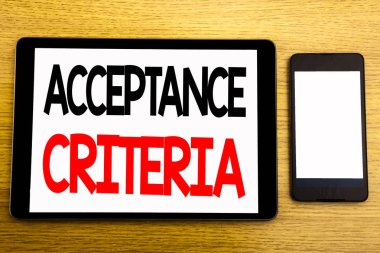 Kabul edilebilirlik kriterleri gösterilen metin yazma. Dijital ölçütü yazılı tablet laptop, yapışkan not, kahve ve kalem ile ahşap arka plan için iş kavramı