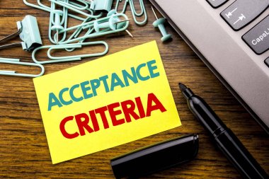 El yazısı duyuru metni kabul edilebilirlik kriterleri gösterilen. Dijital yapışkan not kağıdı laptop klavye yanında ahşap zemin üzerine marker ile yazılı ölçütü için iş kavramı