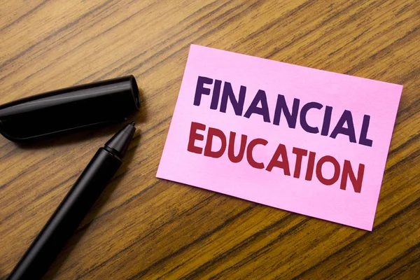 Palabra, escribiendo Educación Financiera. Concepto de negocio para Finanzas Conocimiento Escrito en papel rojo nota adhesiva, fondo de madera con pluma. Nota pegada en el escritorio . —  Fotos de Stock