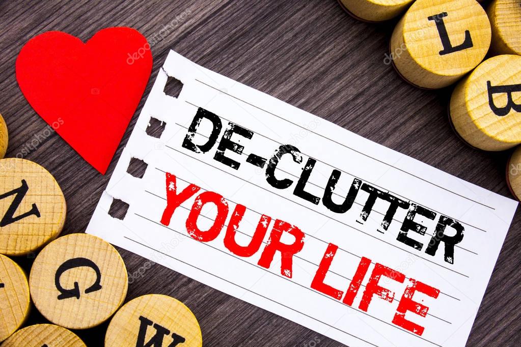 Handwriting text showing De-Clutter Your Life. Conceptual photo Free Less Chaos Fresh Clean Routine written on tear note paper sticky note on the wooden background with heart.