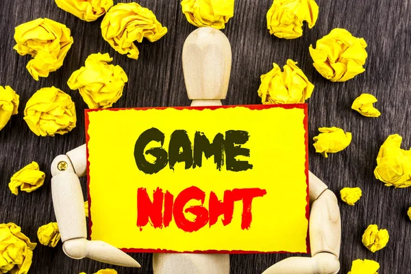 Texto de anúncio mostrando Game Night. Conceito que significa Entertainment Fun Play Time Event For Gaming escrito em Sticky Note Holding By Sculpture no fundo de madeira — Fotografia de Stock