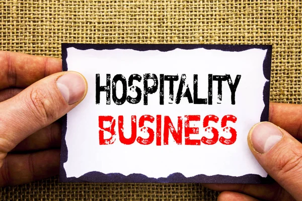 Escrevendo texto mostrando Hospitality Business. Conceito que significa Indústria Negócios Turismo Anúncio escrito em papel de nota pegajosa Segurando a mão com o dedo . — Fotografia de Stock