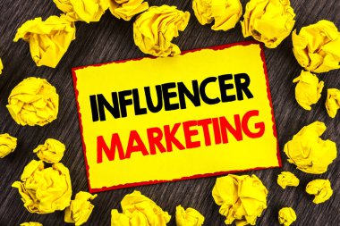 El yazısı duyuru metni Influancer pazarlama. Kavramsal fotoğraf Sosyal Medya Online etkisi ahşap zemin üzerine sarı Stikcy Not katlanmış kağıt üzerinde yazılı stratejisi