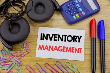 Stok Yönetimi gösterilen metin yazma. Yapışkan not kağıdına ahşap arka plan üzerinde yazılı hisse senedi tedarik için iş kavramı. Hesap makinesi ve kalem marker ve kulaklık ile