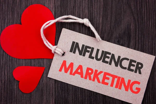 Handschriftlicher Ankündigungstext, der Influencer Marketing zeigt. Geschäftskonzept für Social Media Online-Einflussstrategie auf Preisschild mit roten Wörtern auf dem hölzernen Hintergrund. — Stockfoto