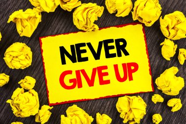 El yazısı duyuru metni hiç Give Up. Kavramsal fotoğraf motivasyon alıntı için başarı başarı ahşap zemin üzerine sarı Stikcy Not katlanmış kağıt üzerinde yazılı meydan okuma