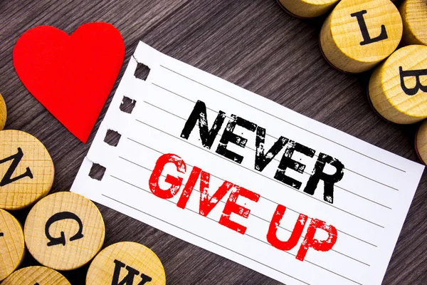 Testo calligrafico che mostra Never Give Up. Foto concettuale Motivazione Preventivo per il successo Sfida di successo scritta su carta strappare nota appiccicosa sullo sfondo di legno con il cuore . — Foto Stock
