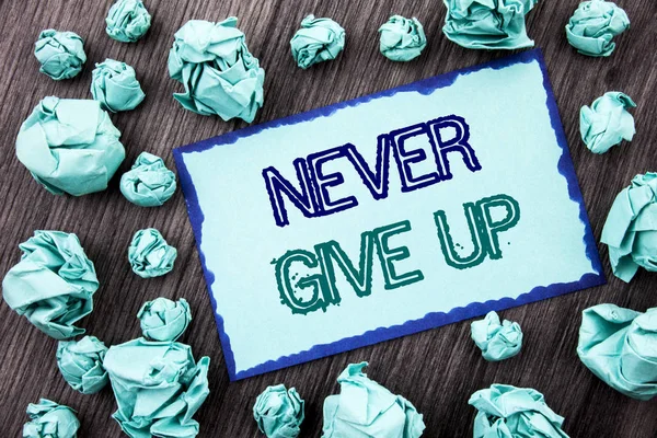 Conceptual hand writing text showing Never Give Up. Concept meaning Motivation Quote For Success Achievement Challenge written on Sticky note paper folded paper on the wooden background. — Stock Photo, Image