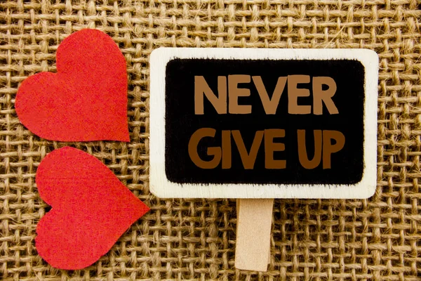 Texto de mano conceptual que muestra Never Give Up. Foto de negocios mostrando Motivation Quote For Success Achievement Challenge escrito en pizarra sobre el fondo texturizado con Love Heart — Foto de Stock