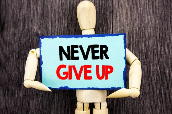 Scrivere un testo che mostra Never Give Up. Concetto che significa motivazione Preventivo per il successo Sfida di successo scritta su Appiccicoso Note Holding By Sculpture sullo sfondo di legno . — Foto Stock