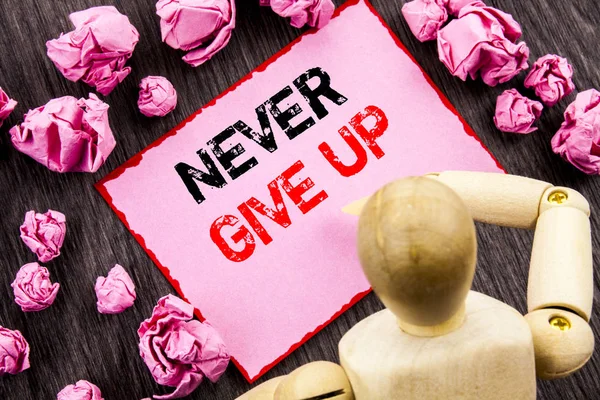 Conceptual hand text showing Never Give Up. Concept meaning Motivation Quote For Success Achievement Challenge written on Sticky Note Holding By Sculpture on the wooden background. — Stock Photo, Image