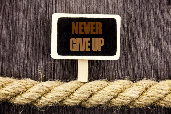 Conceptual writing text showing Never Give Up. Business photo showcasing Motivation Quote For Success Achievement Challenge written Blackboard Hanging on the rope on the wooden background — Stock Photo, Image