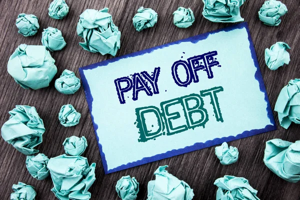 概念性手写文字显示还清债务。概念含义提醒支付欠财务信用贷款票据写在粘纸条纸折叠纸上的木质背景. — 图库照片