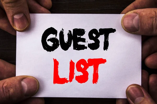 Conceptual hand writing text showing Guest List. Concept meaning Planning Wedding Or Event Important Guests Lists written on Sticky Note Paper Holding Hand with Finger.