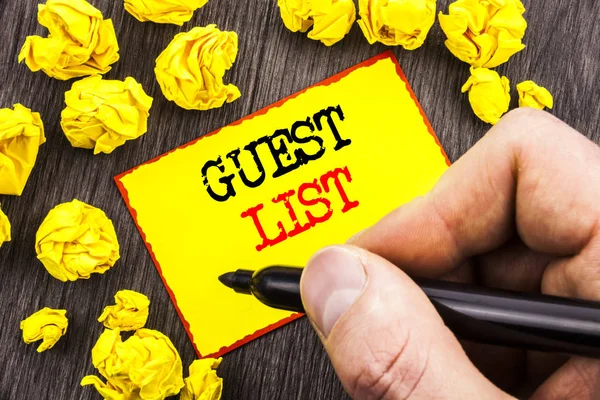 Word, writing, text  Guest List. Business concept for Planning Wedding Or Event Important Guests Lists written By Man Holding Marker on Sticky Note Foded Paper.
